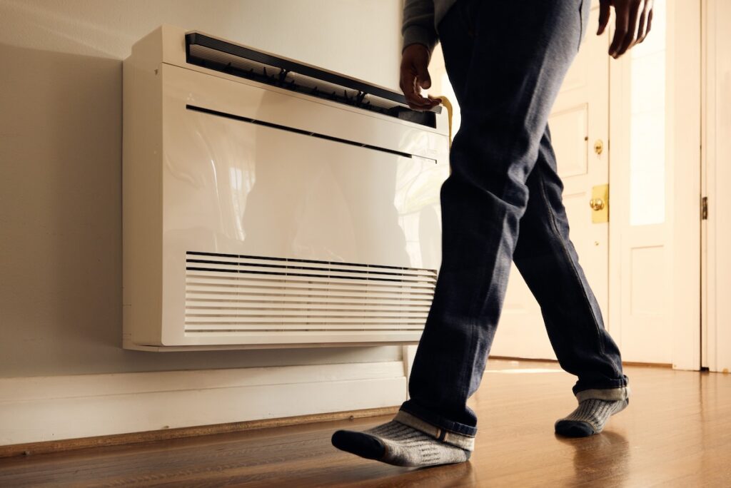 photo of a person walking by a heater
