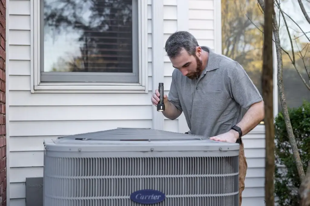 a man inspecting a carrier hvac unit